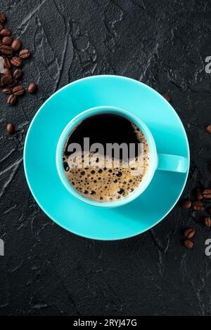 Teal coffee cup and coffee beans, top shot on a black background Stock Photo