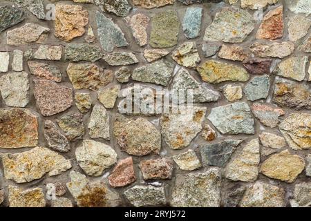 Front view of gray stone wall with cement solution. Stock Photo