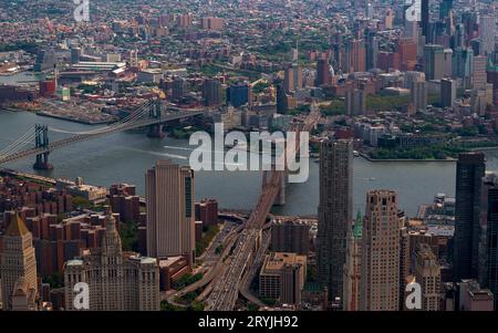 Aerial cityscape about New York city. The east river in the middle. Manhatttan and Brooklyn bridges are over the river. Brooklyn is on the background. Stock Photo