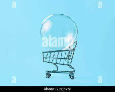 Shopping cart with soap bubble on blue background Stock Photo