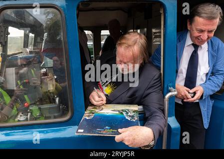 Rick Wakeman in cab of Class 31 diesel loco at Mangapps Railway Museum. Autographing Yes LP Tales From Topographic Oceans, adding 'train driver' Stock Photo