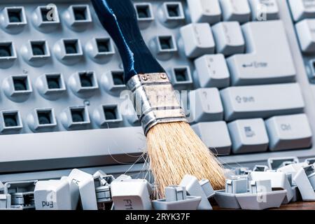 Brush on the old broken computer keyboard Stock Photo