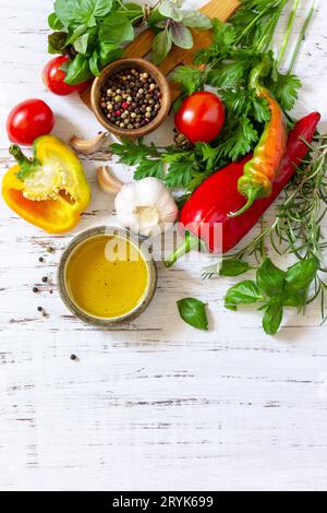 Seasoning background. Fresh and dry herbs, spices, olive oil and vegetables on a wooden table. Top view flat lay background. Cop Stock Photo