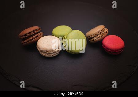 Colorful macaroni on a black slate background. Close-up in different positions placed. Stock Photo