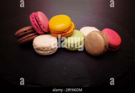 Colorful macaroni on a black slate background. Close-up in different positions placed. Stock Photo