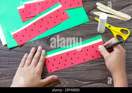 Instruction step 4. Paper Fan watermelon and origami paper ice cream on a wooden table. Childrens art project, handmade, crafts Stock Photo