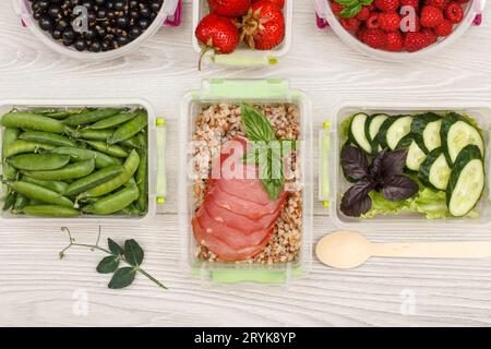 Plastic meal prep containers with buckwheat porridge, meat, vegetables and fruits. Stock Photo