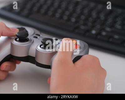 A young man playing video games using a gamepad. Close up. Stock Photo