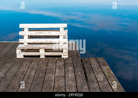 Bench made from old pallets on a wooden pier Stock Photo