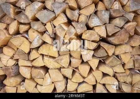 Chopped dry firewood stacked for fireplace, irregular rustic background. Stock Photo
