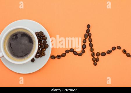 Cup of coffee on a saucer with coffee beans folded in the form of a cardiogram Stock Photo