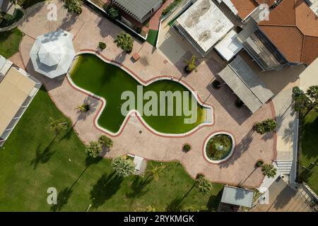 Drone aerial of abandoned deserted hotel swimming pool. Dirty water