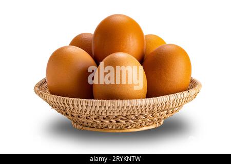 Group of raw chicken eggs in bamboo basket isolated on white background. Stock Photo