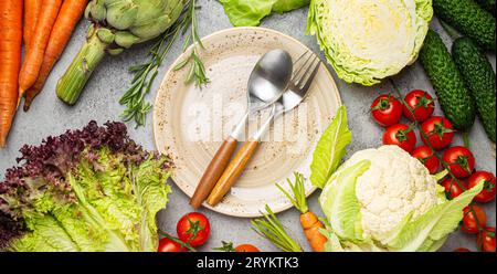 Assorted food raw products: vegetables, beef meat, fish salmon and empty plate in centre, dark rustic brown stone table top view Stock Photo