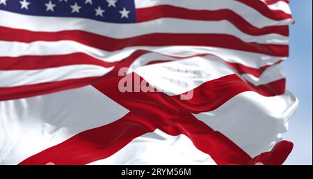 The flag of the state of Alabama waving alongside the national flag of the United States on a sunny day Stock Photo