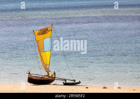 Tranquil scene of a wooden fishing boat resting on the golden sands of Nosy Ve, Madagascar Stock Photo