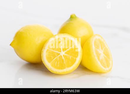 Dwarf lemons isolated on white marble background Stock Photo