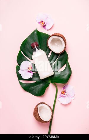 Coconut oil and tropical leaves and flowers. Hair care spa concept Stock Photo