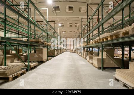 Interior of spacious industrial warehouse with metal shelves Stock Photo