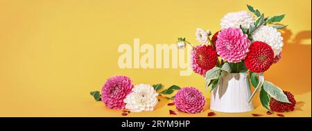 Autumn dahlias flowers bouquet on yellow table. Wall table background, banner format Stock Photo