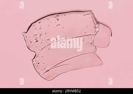 Transparent liquid gel spot on pink background. Textured smear with oxygen bubbles Stock Photo