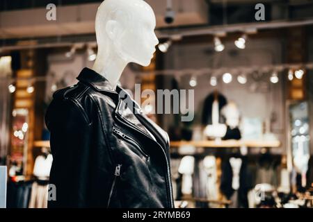 White mannequin in black leather jacket in fashion store, selective focus Stock Photo