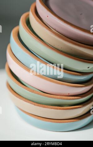 A large stack of ceramic cups in pastel colors. Stock Photo