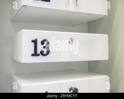 Boxes in the post office. Mini safe with key. The concept of secure storage. Box numbers 13. Personal mailbox Stock Photo