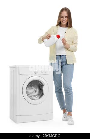 Beautiful young woman pouring detergent into cap near washing machine on white background Stock Photo