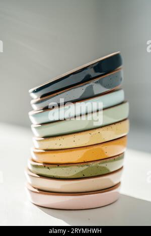 A large stack of ceramic cups in pastel colors. Stock Photo