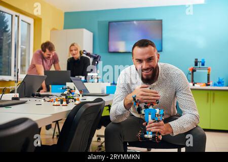 A group of colleagues working together in a robotics laboratory, focusing on the intricate fields of robotics and 3D printing. S Stock Photo