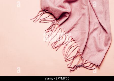 Pink cozy scarf with tassels on pastel background. Minimal winter or autumn background for your design Stock Photo