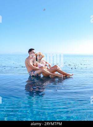 Couple man and women in front of Infinity pool looking out over the ocean of Cape Town South Africa Stock Photo