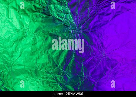 Violet green deformed background made of neon lights foil. Trendy duotone texture Stock Photo