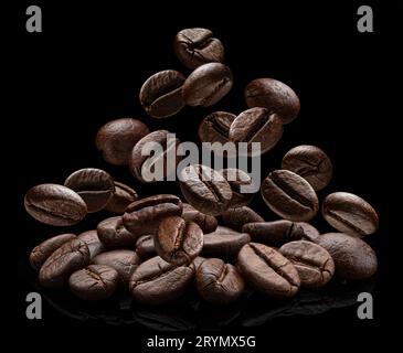 Falling coffee beans isolated on black background Stock Photo