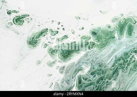 Fluid Art acrylic paints. Abstract mixing green waves on white background. Liquid flows splashes. Marble effect background or te Stock Photo