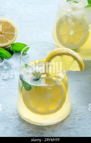 Lemonade with mint. Lemon water drink with ice. A glass and a pitcher Stock Photo