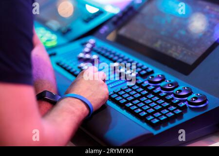 Light board operator working on stage lighting control console. Selective focus. Stock Photo