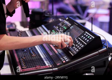 Sound mixing console operator checks settings before live event. Selective focus. Stock Photo