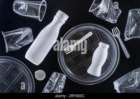 Plastic disposable tableware on black background. Environmental pollution concept Stock Photo