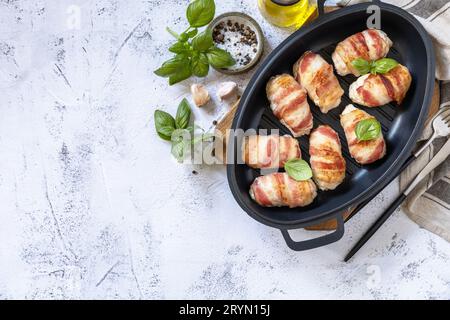 A festive dish. Baked chicken fillet with ricotta in bacon on a stone table top. Top view flat lay background. Copy space. Stock Photo