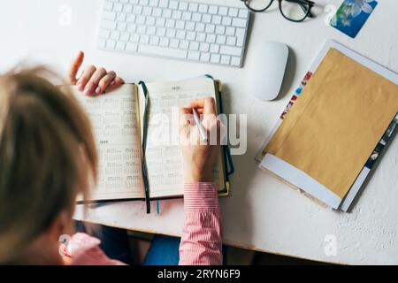 Top view woman writes on calendar Stock Photo