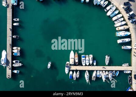 Drone aerial scenery of a fishing port. Fishing boats and yachts moored in the harbour. Stock Photo