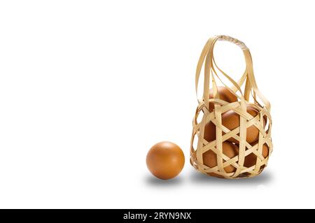Group of fresh chicken eggs in bamboo basket isolated on white background. Stock Photo