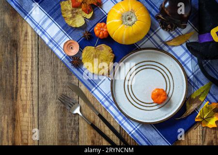 Halloween day decoration party, Halloween festive table setting with pumpkins and autumn leaves. Top view flat lay background. C Stock Photo