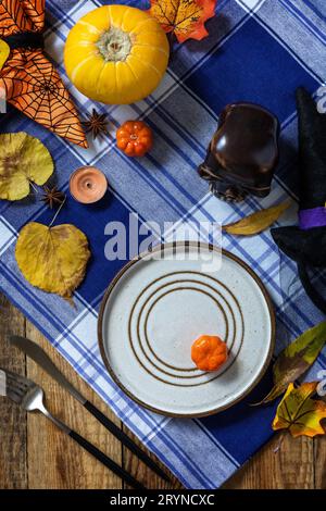 Halloween day decoration party, Halloween festive table setting with pumpkins and autumn leaves. Top view flat lay background. Stock Photo