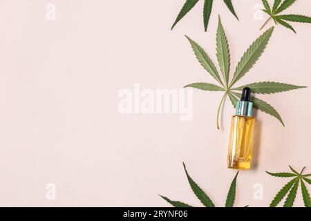 Natural cosmetic. Herbal Alternative Medicine Concept. Cannabis face serum or oil dropper concept and hemp leaves on beige backg Stock Photo