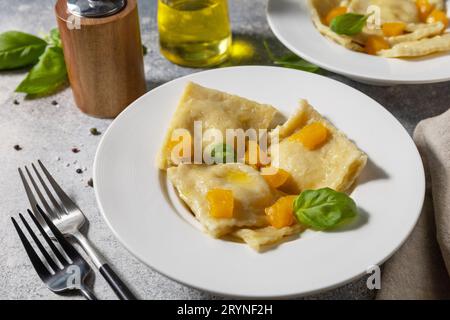 Homemade Italian pumpkin ricotta ravioli on a gray stone tabletop. Stock Photo