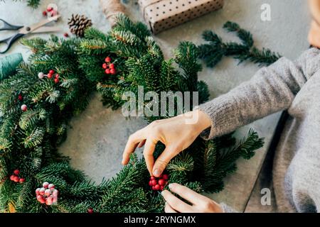 A woman is crafting a wreath for Christmas. Natural natural decoration Stock Photo
