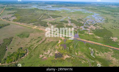 Aerial view of Transpantaneira dirt road crossing in typical Pantanal Wetlands landscape with lagoon Stock Photo